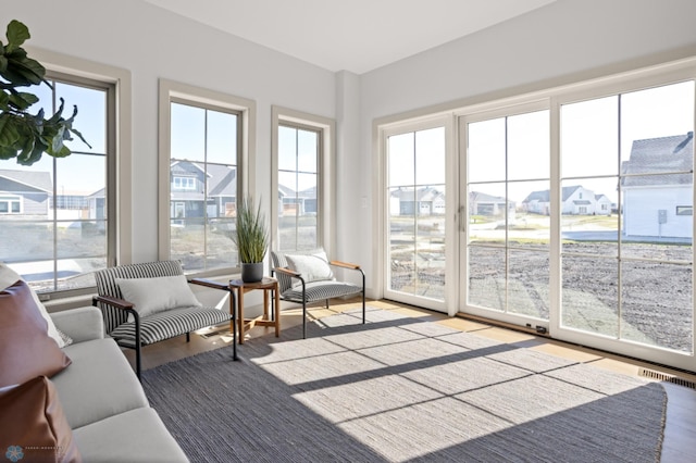 sunroom / solarium with visible vents and wood finished floors