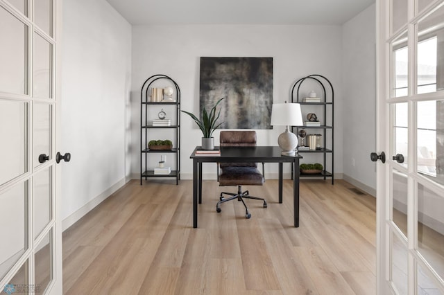 office space with baseboards, visible vents, french doors, and light wood-style flooring