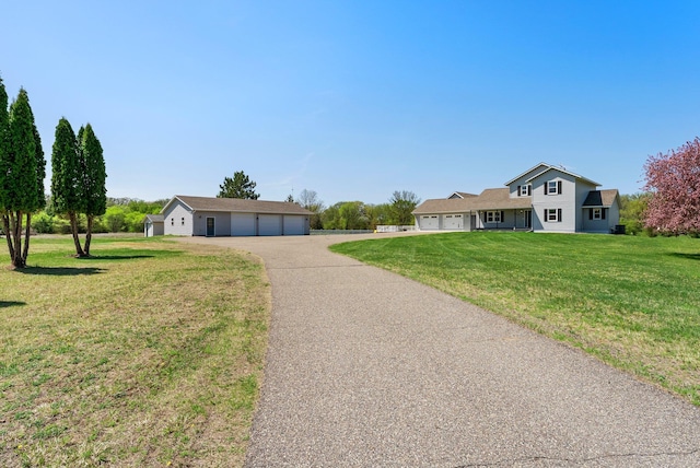 view of front facade with asphalt driveway, a front yard, and a garage