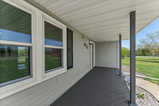 wooden terrace with a yard and covered porch