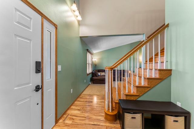 foyer with wood finished floors, stairs, and baseboards