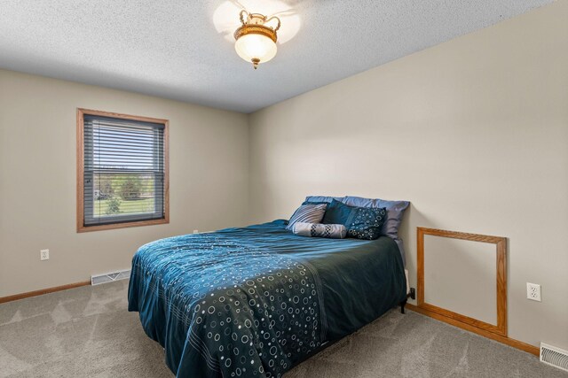 carpeted bedroom featuring baseboards and a textured ceiling