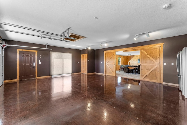 garage featuring freestanding refrigerator and baseboards