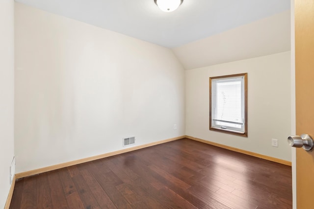 1852 Quincy St NE, Minneapolis, MN 55418 - spare room with dark wood-style flooring, lofted ceiling, baseboards, and visible vents