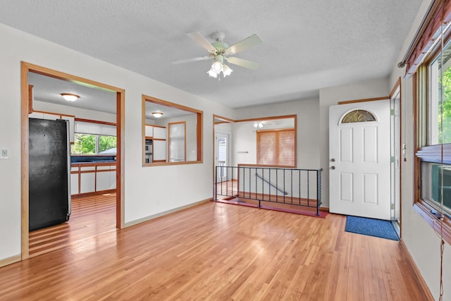 1791 Lois Dr, Shoreview, MN 55126 - foyer with light wood-type flooring, a textured ceiling, baseboards, and a ceiling fan