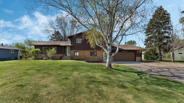 tri-level home with an attached garage, brick siding, dirt driveway, and a front yard