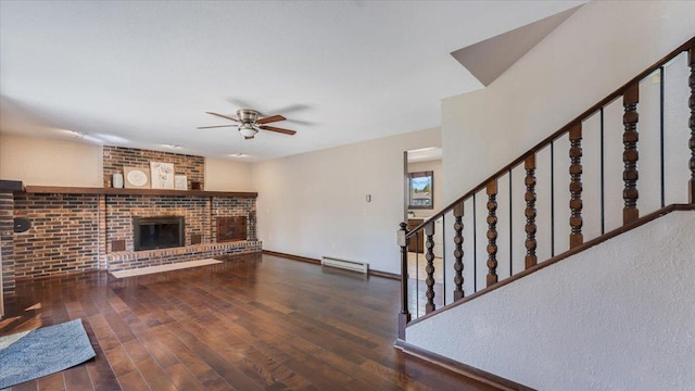 unfurnished living room with a baseboard heating unit, a ceiling fan, stairs, and wood finished floors