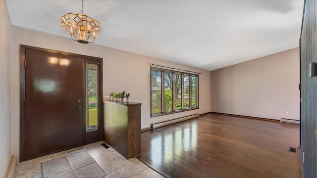 foyer featuring baseboard heating, a chandelier, wood finished floors, and baseboards