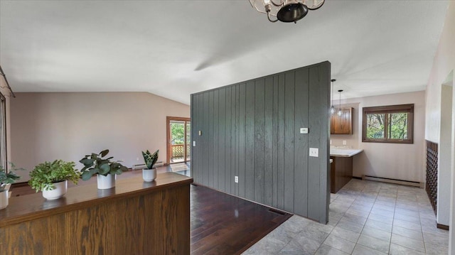 unfurnished office with baseboard heating, vaulted ceiling, and a chandelier
