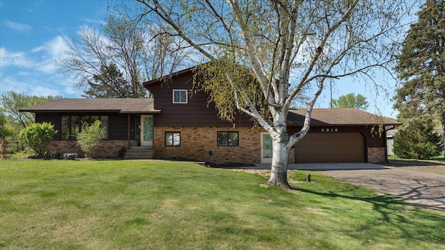tri-level home featuring brick siding, an attached garage, driveway, and a front lawn