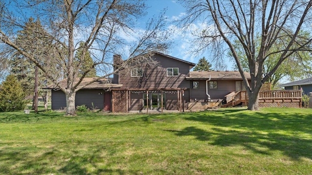 back of property featuring a deck, a chimney, and a yard