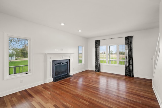 unfurnished living room featuring recessed lighting, baseboards, wood finished floors, and a fireplace