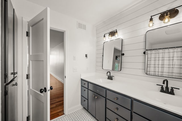 full bath with double vanity, tile patterned floors, visible vents, and a sink