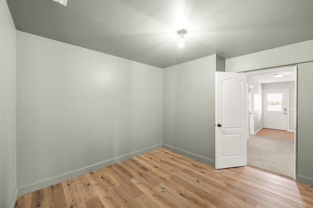 spare room featuring baseboards and light wood-style flooring