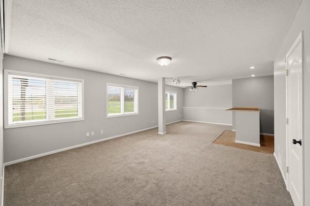 interior space featuring a ceiling fan, baseboards, recessed lighting, a textured ceiling, and carpet flooring