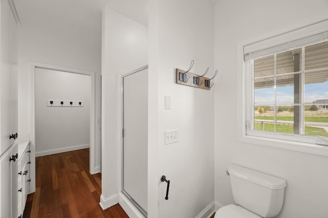 bathroom featuring an enclosed shower, baseboards, toilet, and wood finished floors