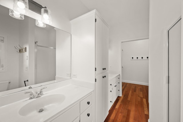 bathroom featuring toilet, wood finished floors, and vanity