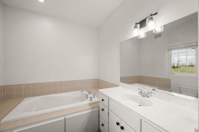 bathroom with toilet, visible vents, a bath, and vanity