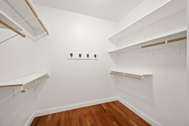 walk in closet with wood finished floors