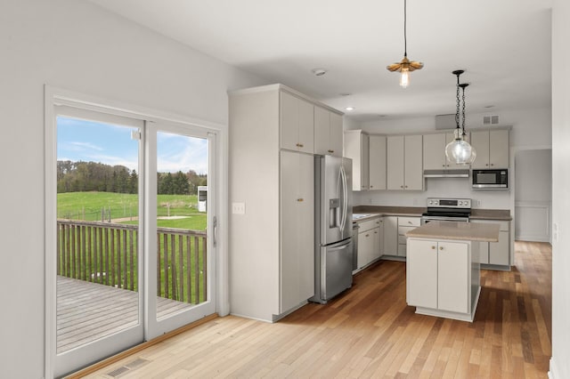 kitchen with visible vents, under cabinet range hood, hardwood / wood-style floors, and stainless steel appliances