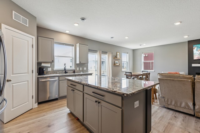 kitchen featuring visible vents, a sink, gray cabinetry, and stainless steel appliances
