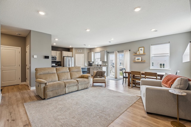 living area featuring recessed lighting, baseboards, light wood-type flooring, and visible vents