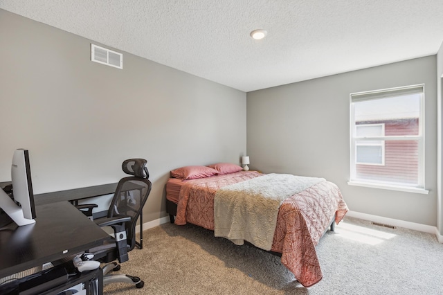 bedroom featuring carpet floors, baseboards, a textured ceiling, and visible vents
