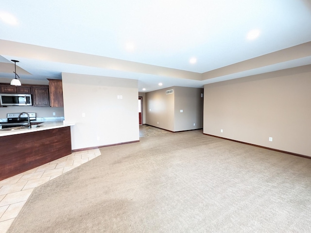 580 Canyon Ln NW, Eyota, MN 55934 - unfurnished living room featuring recessed lighting, baseboards, light carpet, light tile patterned flooring, and a sink