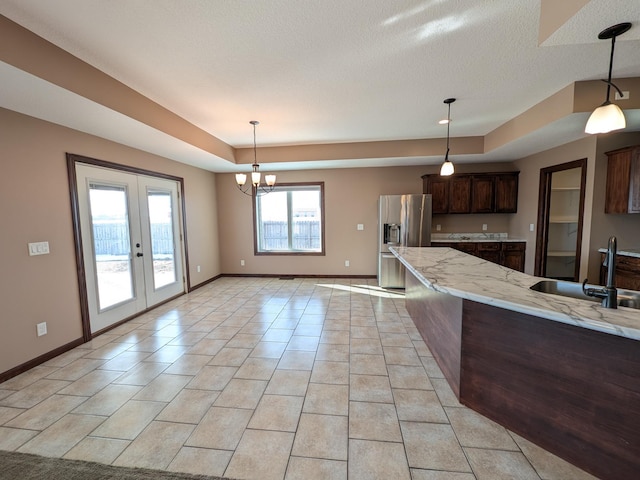 580 Canyon Ln NW, Eyota, MN 55934 - kitchen with a sink, stainless steel fridge, a tray ceiling, dark brown cabinets, and french doors