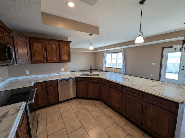 580 Canyon Ln NW, Eyota, MN 55934 - kitchen with appliances with stainless steel finishes, a sink, a peninsula, decorative light fixtures, and a textured ceiling