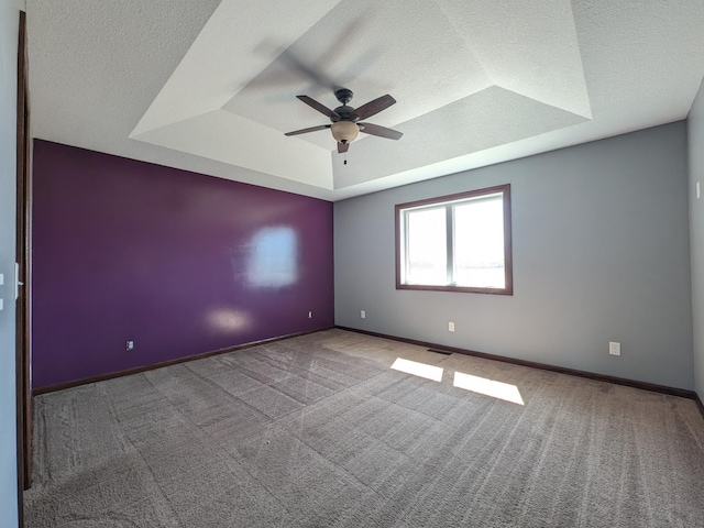 580 Canyon Ln NW, Eyota, MN 55934 - carpeted spare room featuring a tray ceiling, ceiling fan, baseboards, and a textured ceiling