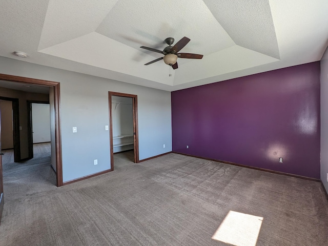 580 Canyon Ln NW, Eyota, MN 55934 - unfurnished bedroom featuring a raised ceiling, carpet floors, baseboards, a spacious closet, and a textured ceiling