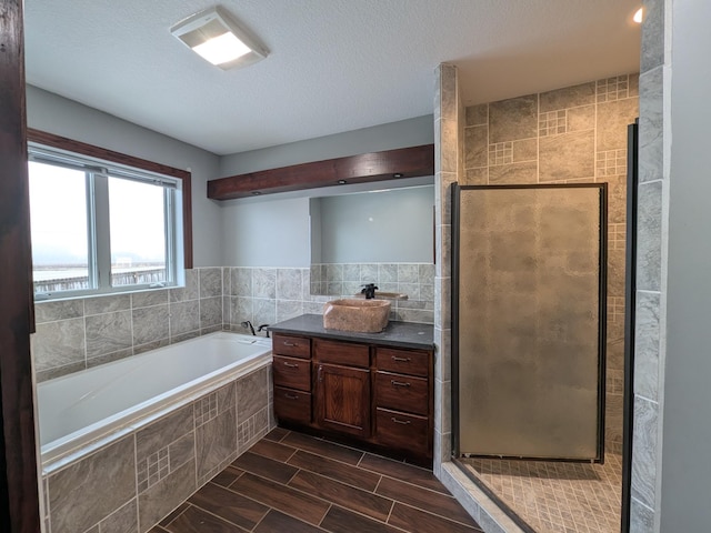 580 Canyon Ln NW, Eyota, MN 55934 - full bathroom featuring a bath, a stall shower, vanity, and a textured ceiling