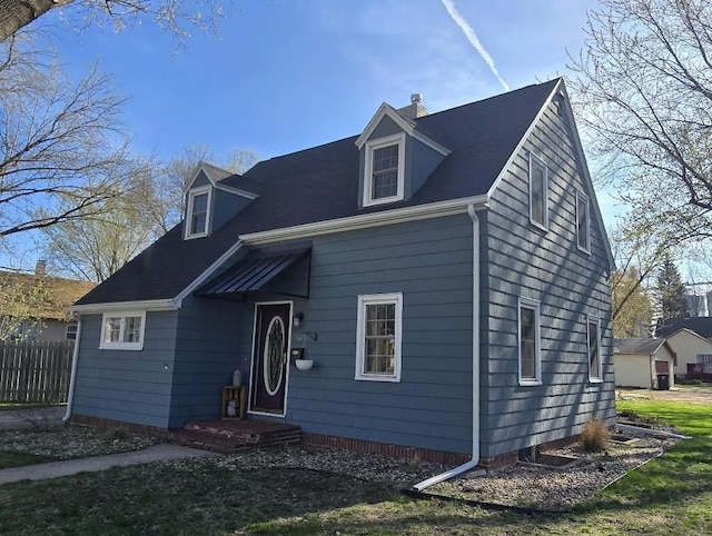 cape cod-style house featuring fence and a chimney