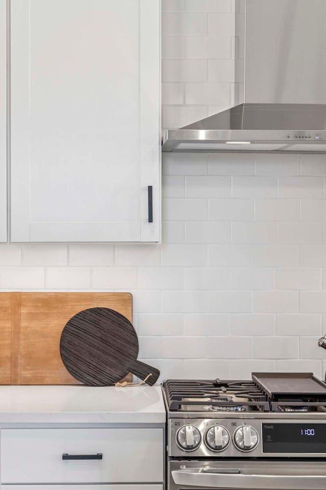 kitchen with stainless steel gas range, white cabinetry, and light countertops