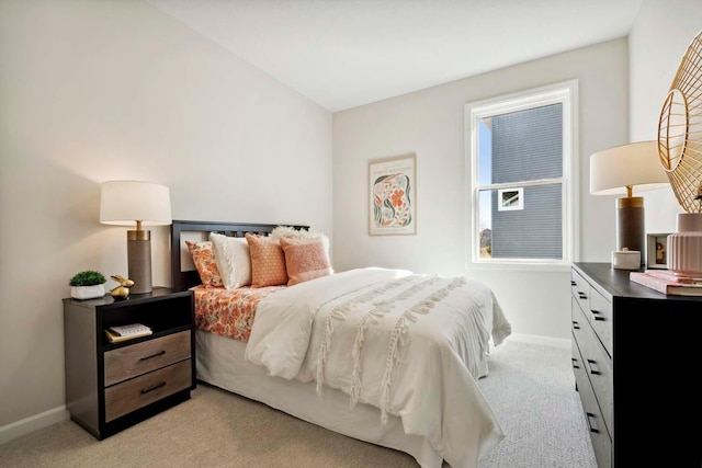 bedroom with baseboards and light colored carpet