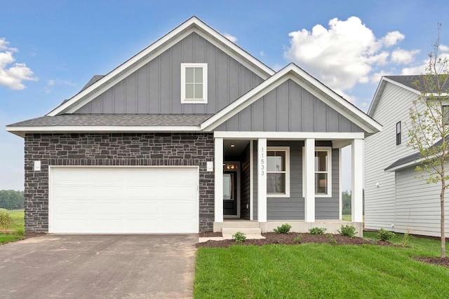 12439 Drayton Trl, Apple Valley, MN 55124 - view of front facade with board and batten siding, a porch, driveway, a front yard, and a shingled roof