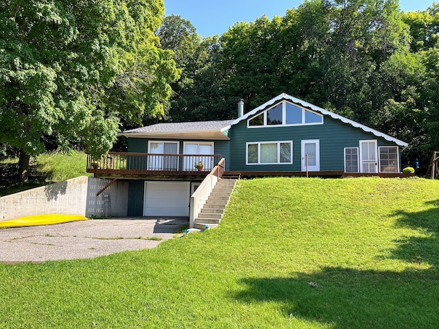 exterior space featuring a garage, a front lawn, gravel driveway, and stairway