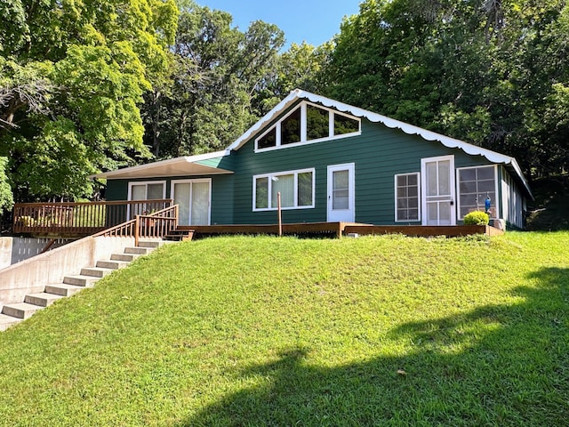 view of front facade featuring a wooden deck, stairs, and a front yard