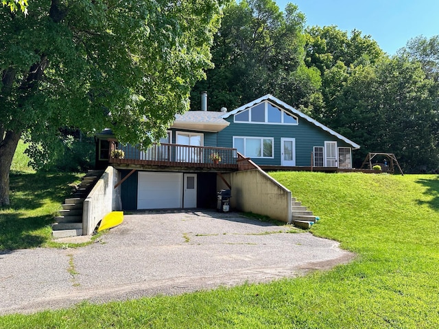 rustic home with stairway, an attached garage, driveway, and a front yard
