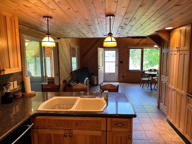 kitchen with dark countertops, open floor plan, black dishwasher, wooden ceiling, and a sink