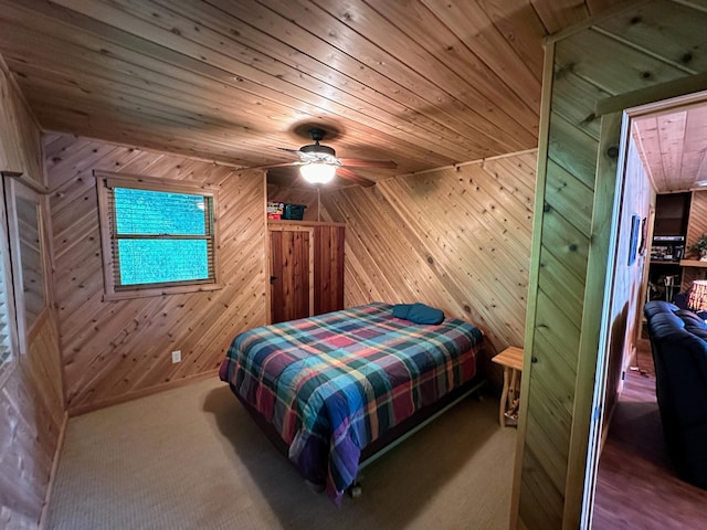 bedroom featuring wood walls, wood ceiling, and carpet