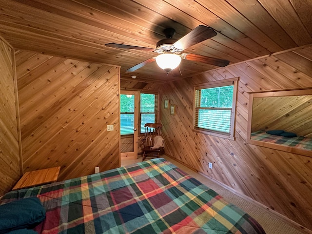 unfurnished bedroom featuring access to outside, wood walls, a ceiling fan, and wooden ceiling