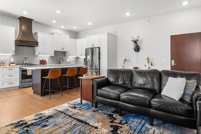 living room with light wood-style floors and recessed lighting