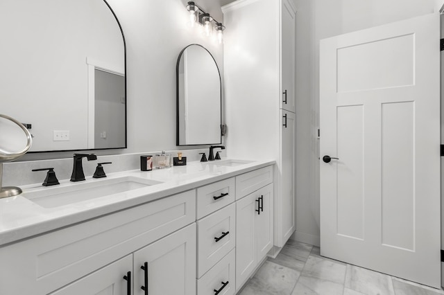 bathroom with double vanity and marble finish floors