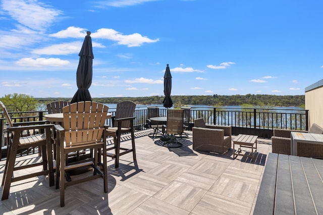 wooden deck featuring a water view, outdoor dining area, and an outdoor living space