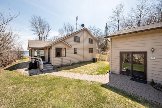 1844 Mount Carmel Dr NE, Alexandria, MN 56308 - rear view of property with a shingled roof, a lawn, and central air condition unit