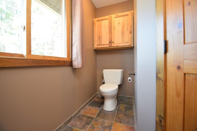 3585 Rigby Rd, Webster, WI 54893 - bathroom with toilet, baseboards, and stone finish flooring