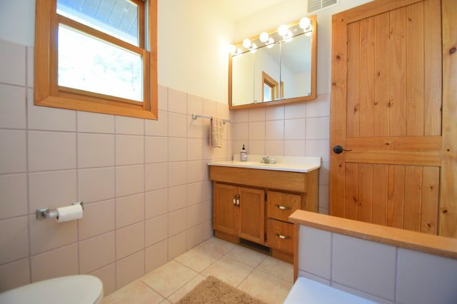 3585 Rigby Rd, Webster, WI 54893 - bathroom featuring visible vents, vanity, toilet, tile walls, and tile patterned floors