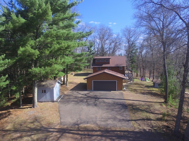 3585 Rigby Rd, Webster, WI 54893 - view of front of house with a garage, an outdoor structure, a shed, aphalt driveway, and stairs